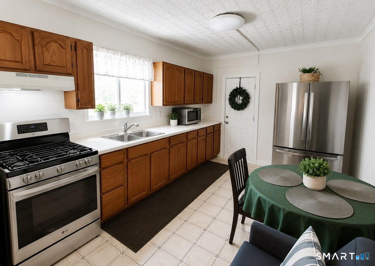 61 Bartlett Street Meriden, CT 06451 - Photo 9 of 30 a kitchen with stainless steel appliances granite countertop a stove a sink a microwave a refrigerator and cabinets