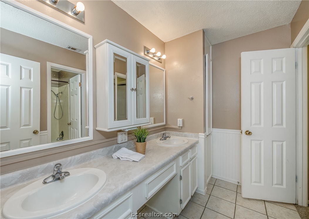 2303 Avon Street Bryan, TX 77802 - Photo 15 of 32 Guest bathroom has double sinks, plenty of cabinetry, separate room with shower & toilet. Storage galore