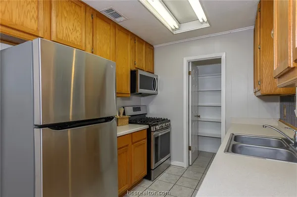 a kitchen with granite countertop a refrigerator and a sink