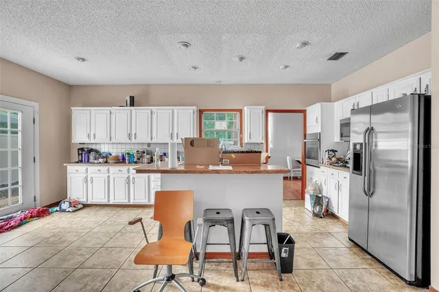 a kitchen with white cabinets and refrigerator