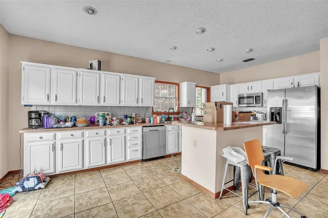 a kitchen with cabinets and chairs
