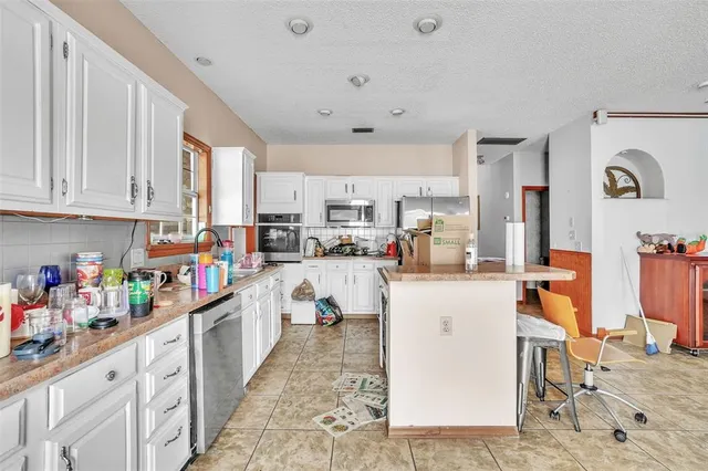 a kitchen with stainless steel appliances granite countertop a refrigerator sink and cabinets