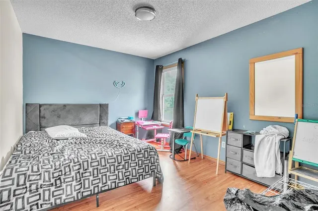 a bedroom with a bed and wooden floor