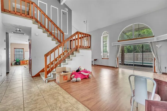 a living room with wooden floor and a chandelier