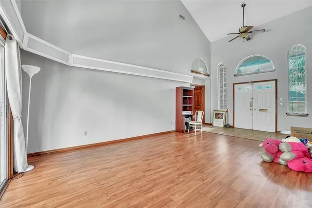 a view of an empty room with wooden floor and a window