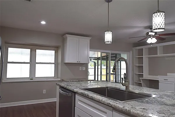 a kitchen with a refrigerator a sink cabinets and a window