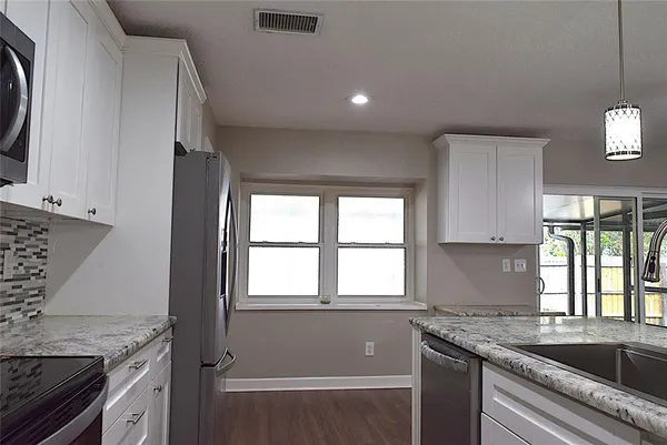 a kitchen with granite countertop a sink stove and cabinets