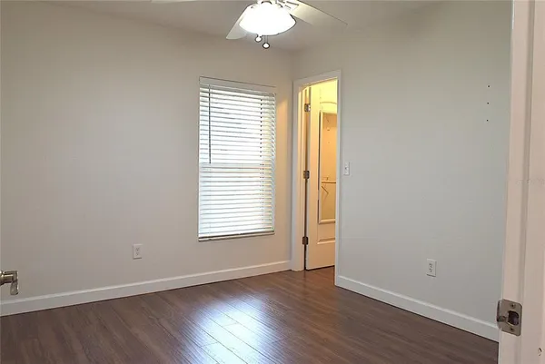 a view of an empty room with wooden floor