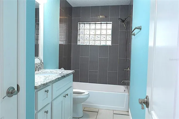 a bathroom with a granite countertop sink toilet and shower