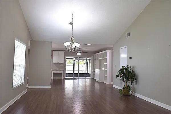 a view of a room with wooden flooring and chandelier