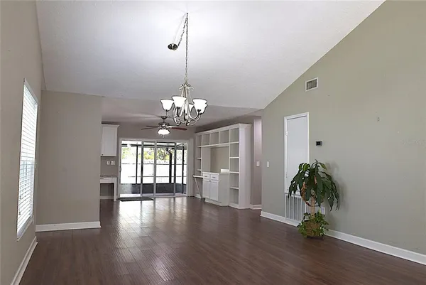 a view of a livingroom with wooden floor and chandelier