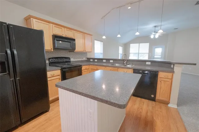 a kitchen with granite countertop a sink and stainless steel appliances