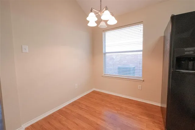 a view of a hallway with wooden floor and closet