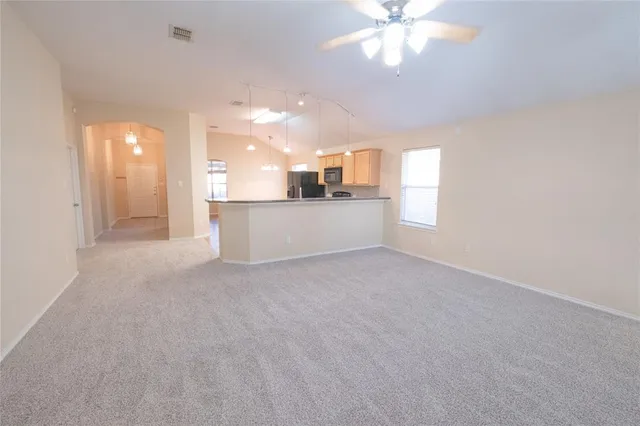 an empty room with windows and fan