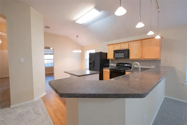 an empty room with windows and chandelier fan