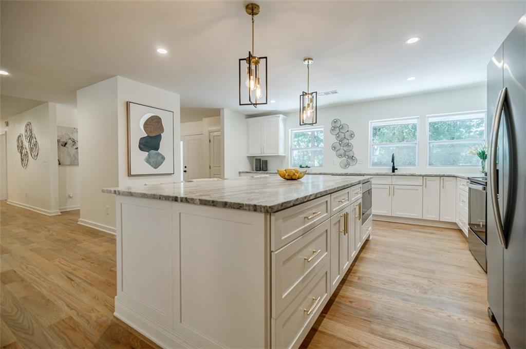 3154 North Druid Hills Road Northeast Decatur, GA 30033 - Photo 39 of 84 a kitchen with stainless steel appliances granite countertop a sink and dishwasher a stove top oven with wooden floor