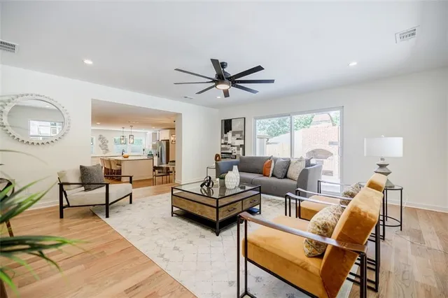 an empty room with wooden floor ceiling fan and windows