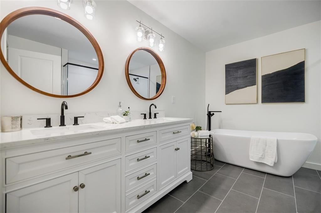 3154 North Druid Hills Road Northeast Decatur, GA 30033 - Photo 66 of 84 a bathroom with a double vanity sink double mirror and bathtub