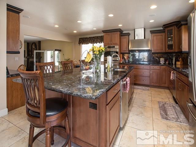 1435 Celese Lane Reno, NV 89511 - Photo 12 of 40 a kitchen with kitchen island granite countertop stainless steel appliances lots of counter top space