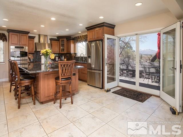 1435 Celese Lane Reno, NV 89511 - Photo 14 of 40 a view of kitchen with stainless steel appliances kitchen island granite countertop dining table chair and a refrigerator