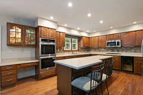 a kitchen with kitchen island a sink appliances and cabinets
