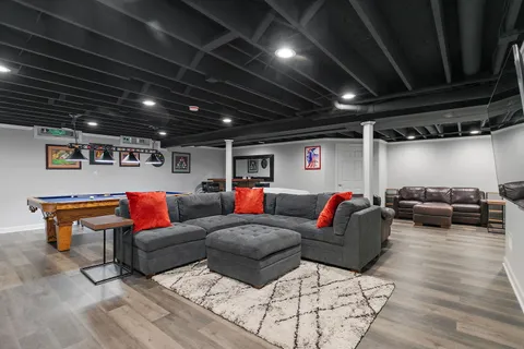 a room with furniture pool table and wooden floor