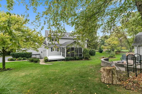 a view of a house with a big yard plants and large trees