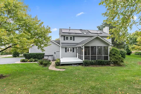 a view of a house with a yard potted plants and large tree