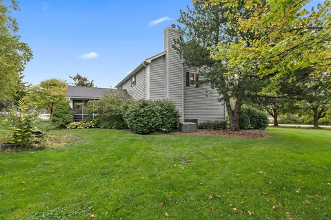 an aerial view of a house with a yard and lake