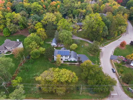 an aerial view of a house with a yard and lake view