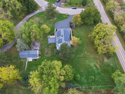 an aerial view of residential houses with outdoor space and trees