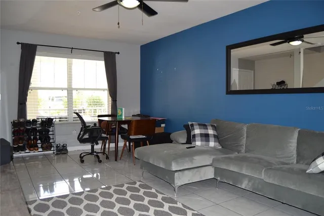 a living room with furniture a dining table and a large window