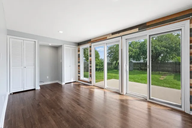 a view of an empty room with wooden floor and a floor to ceiling window