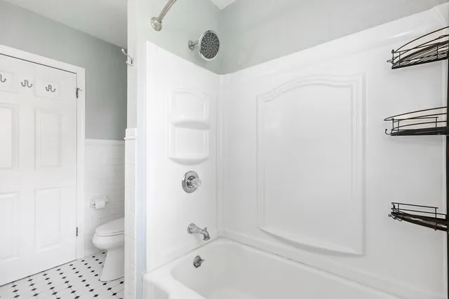 a bathroom with a shower a toilet and a sink