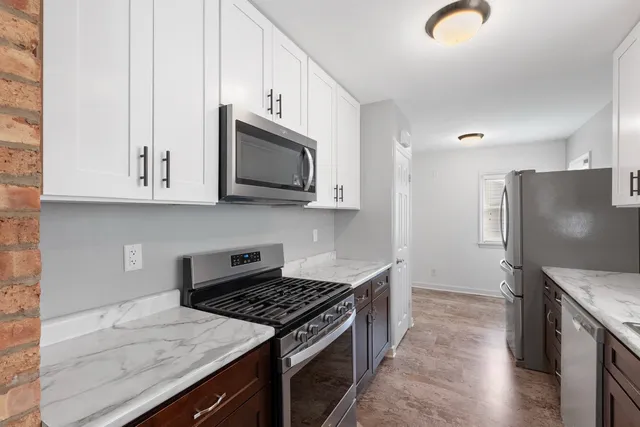 a kitchen with stainless steel appliances granite countertop a stove a refrigerator and a microwave