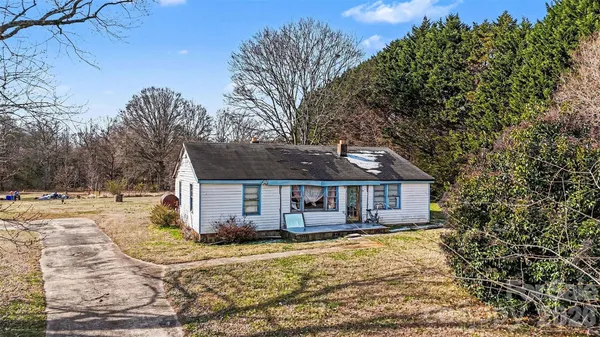 a front view of a house with a yard tree and wooden fence