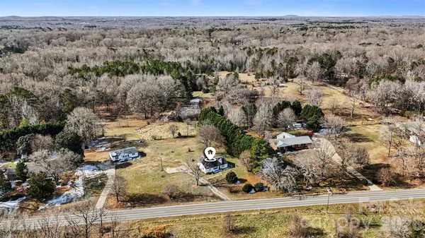 an aerial view of a house with a mountain