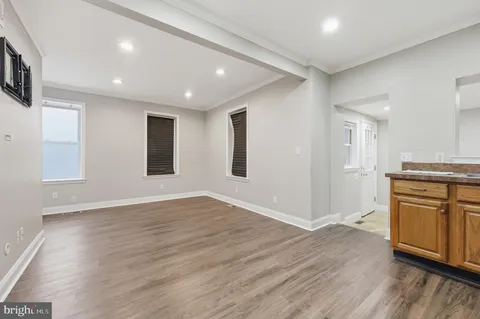 an empty room with wooden floor and cabinet