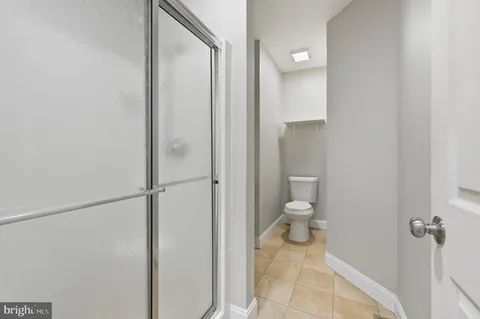 a bathroom with a granite countertop toilet and a shower