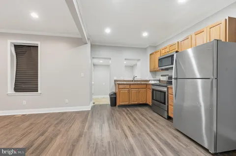 a kitchen with a refrigerator wooden floor and a sink
