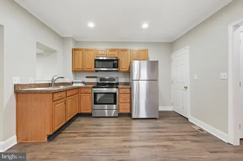 a kitchen with a refrigerator and a stove top oven
