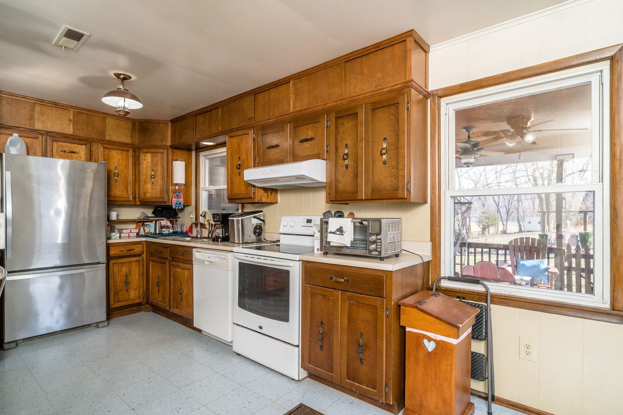 3154 Layman Trestle Road Harrisonburg, VA 22802 - Photo 4 of 30 a kitchen with stainless steel appliances granite countertop a refrigerator a sink dishwasher a stove with wooden cabinets and floors