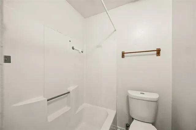 a white toilet sitting next to a bath tub