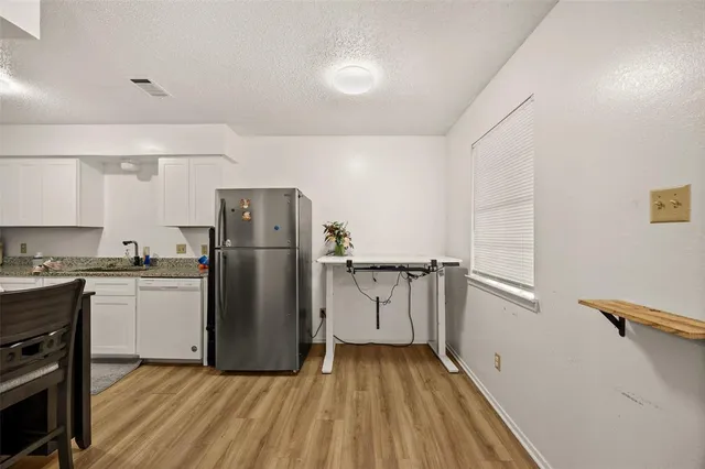 a kitchen with a refrigerator and a stove top oven