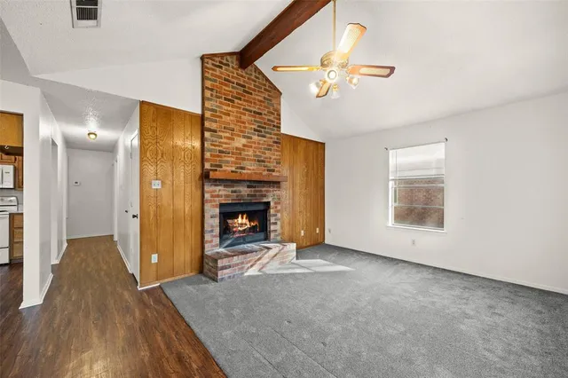 an empty room with a fireplace and wooden floor