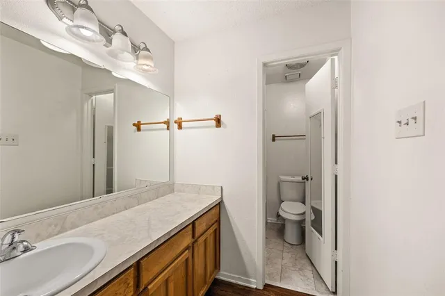 a bathroom with a sink a toilet a mirror and shower