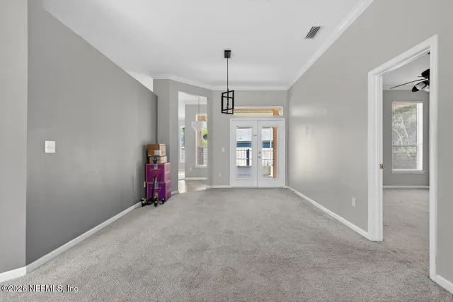 an empty room with a window and a fan