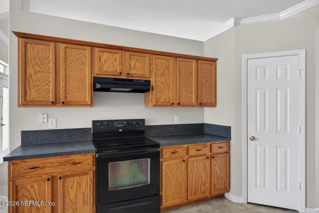 a kitchen with granite countertop a sink stove and cabinets