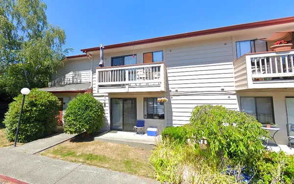 a view of a house with backyard and sitting area