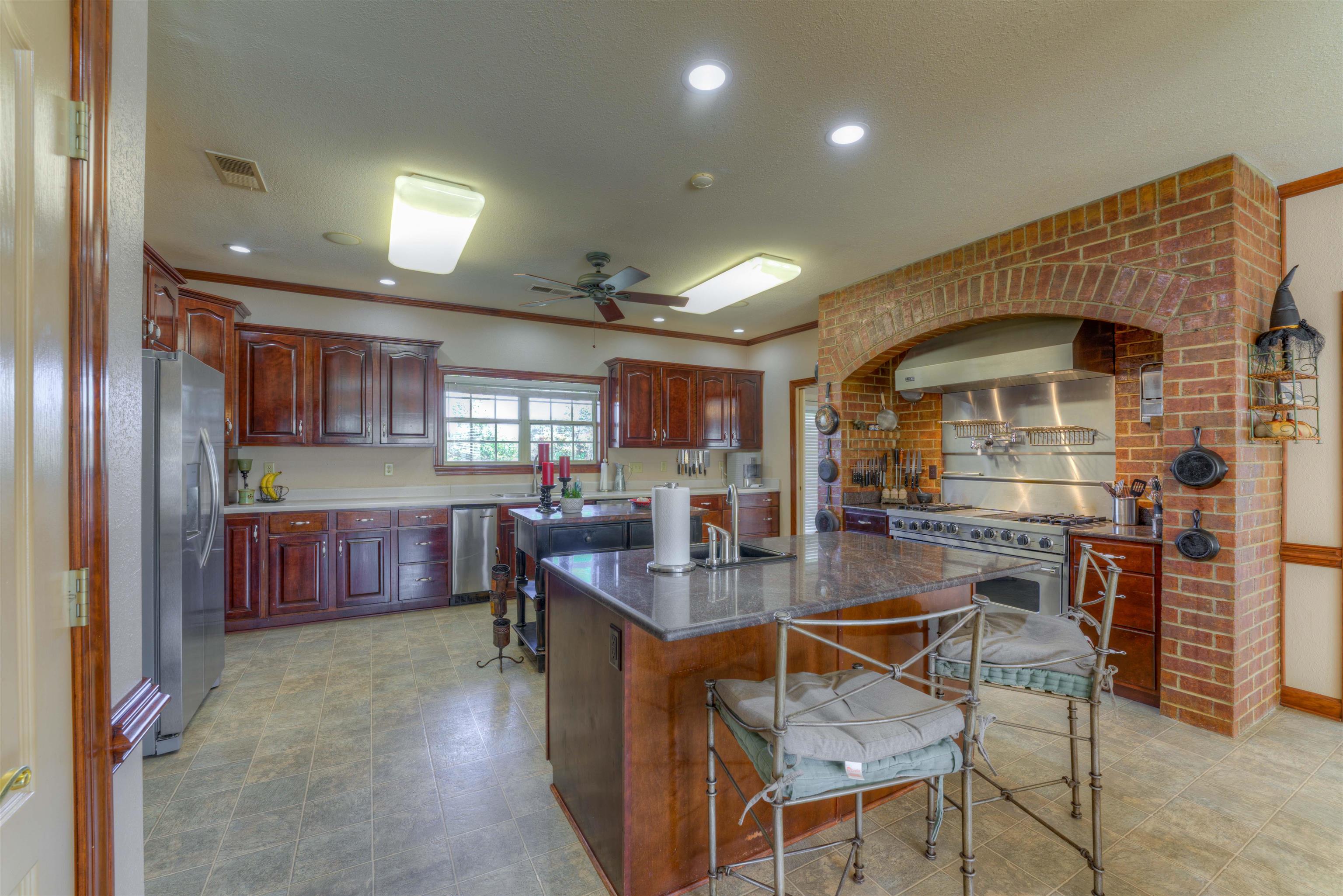 10529 Moose Road Millington, TN 38053 - Photo 18 of 40 a dining hall with stainless steel appliances granite countertop a stove oven a sink dishwasher and cabinets with wooden floor